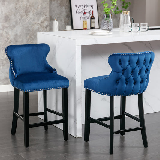 Blue velvet tufted bar stool with silver nailhead trim and dark wood legs