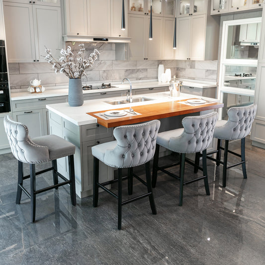 Grey velvet tufted bar stool with silver nailhead trim and black legs