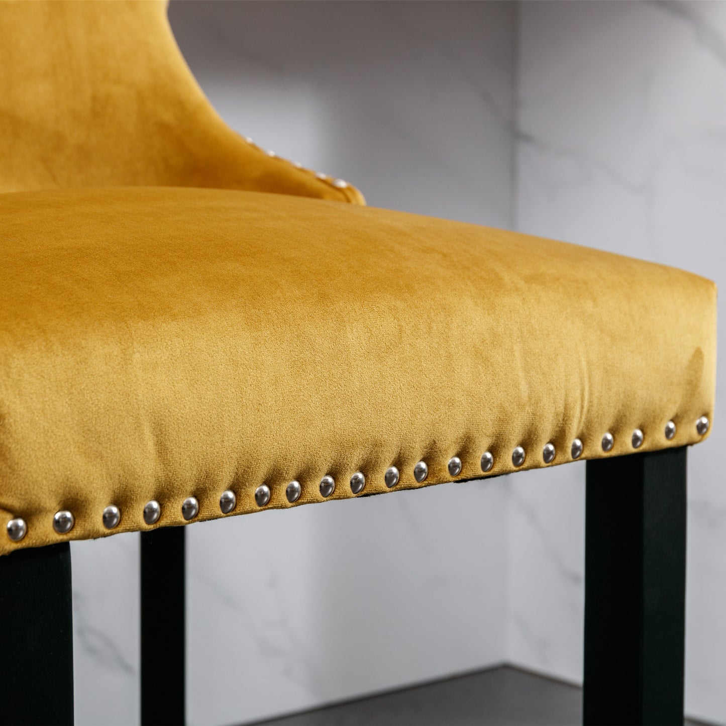 Closeup of mustard yellow velvet bar stool seat with decorative nailhead trim