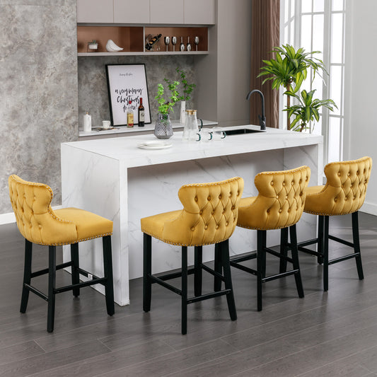 Yellow tufted velvet bar stools with silver nailhead trim and black legs