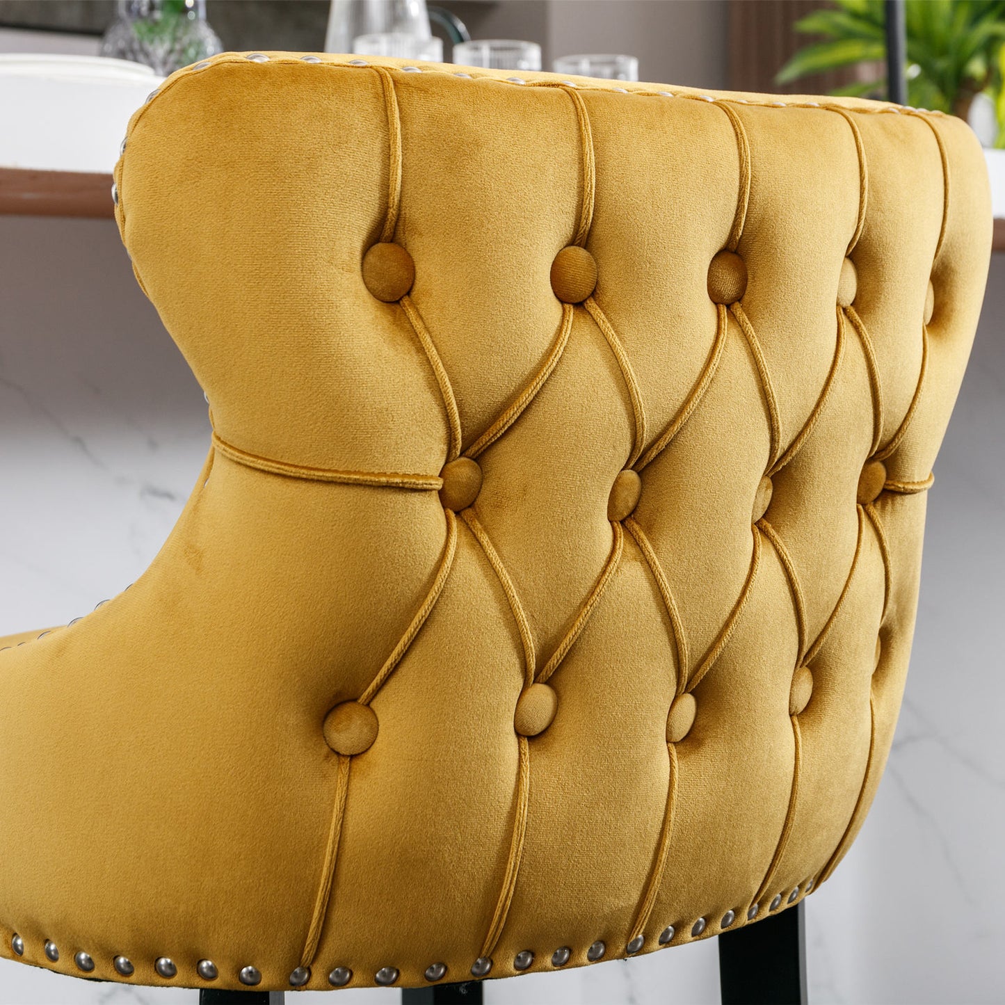 Yellow velvet bar stool with deep tufting and silver nailhead trim