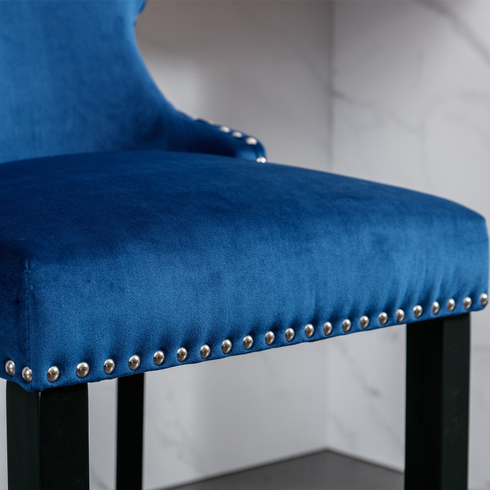 Blue velvet accent chair with decorative nailhead trim and dark wood legs