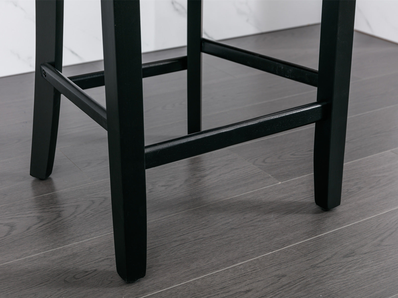 Black wooden bar stool legs on grey wood floor