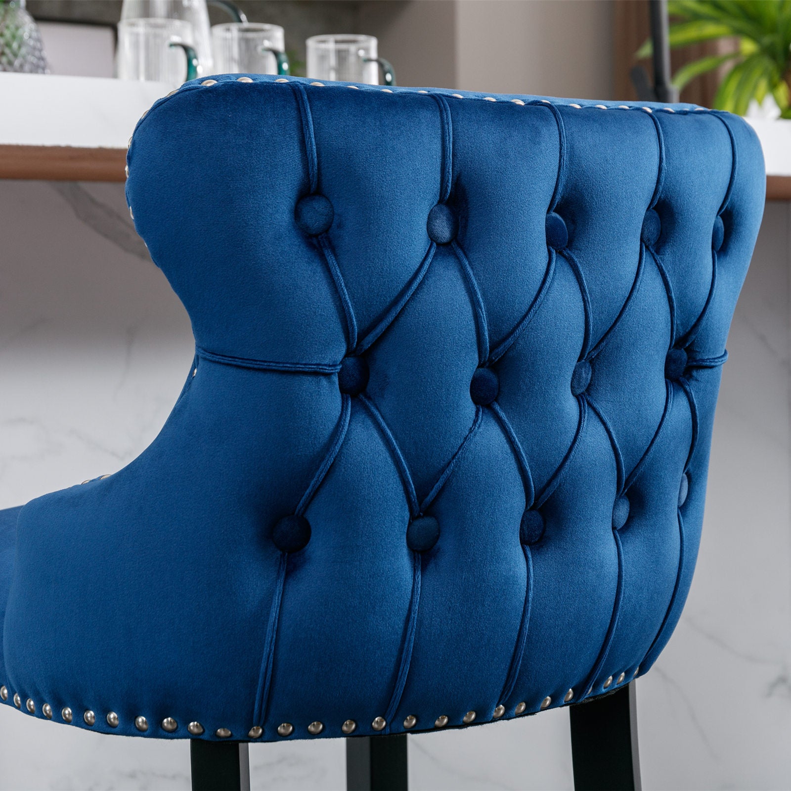 Deep blue velvet bar stool with tufted backrest and silver nailhead trim