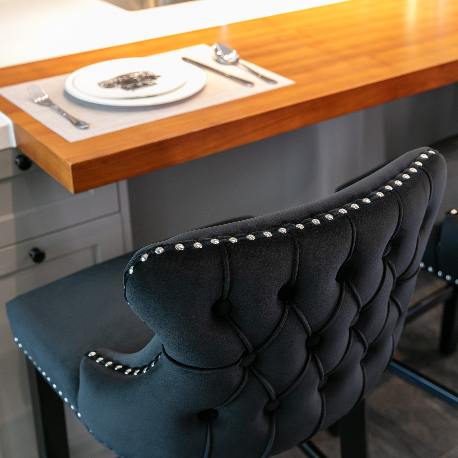 Black velvet tufted bar stool with silver nailhead trim