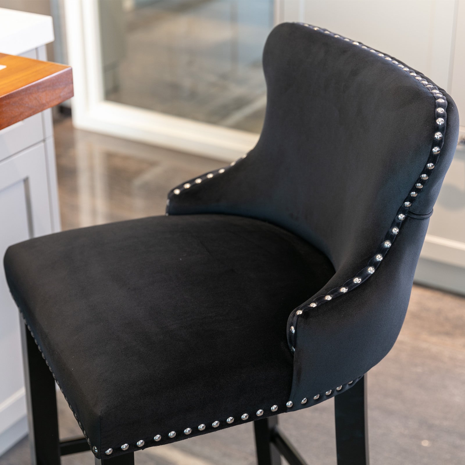 Black velvet bar stool with silver nailhead trim and curved back