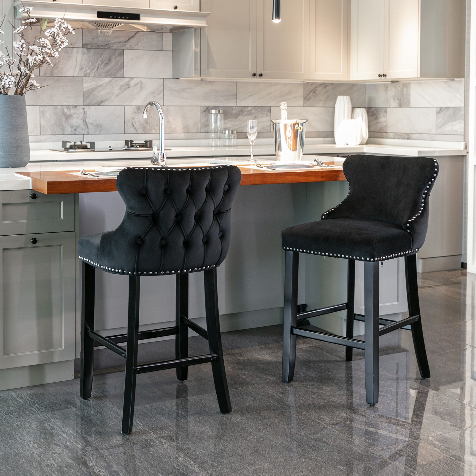 Tufted black velvet bar stool with silver nailhead trim and dark wood legs