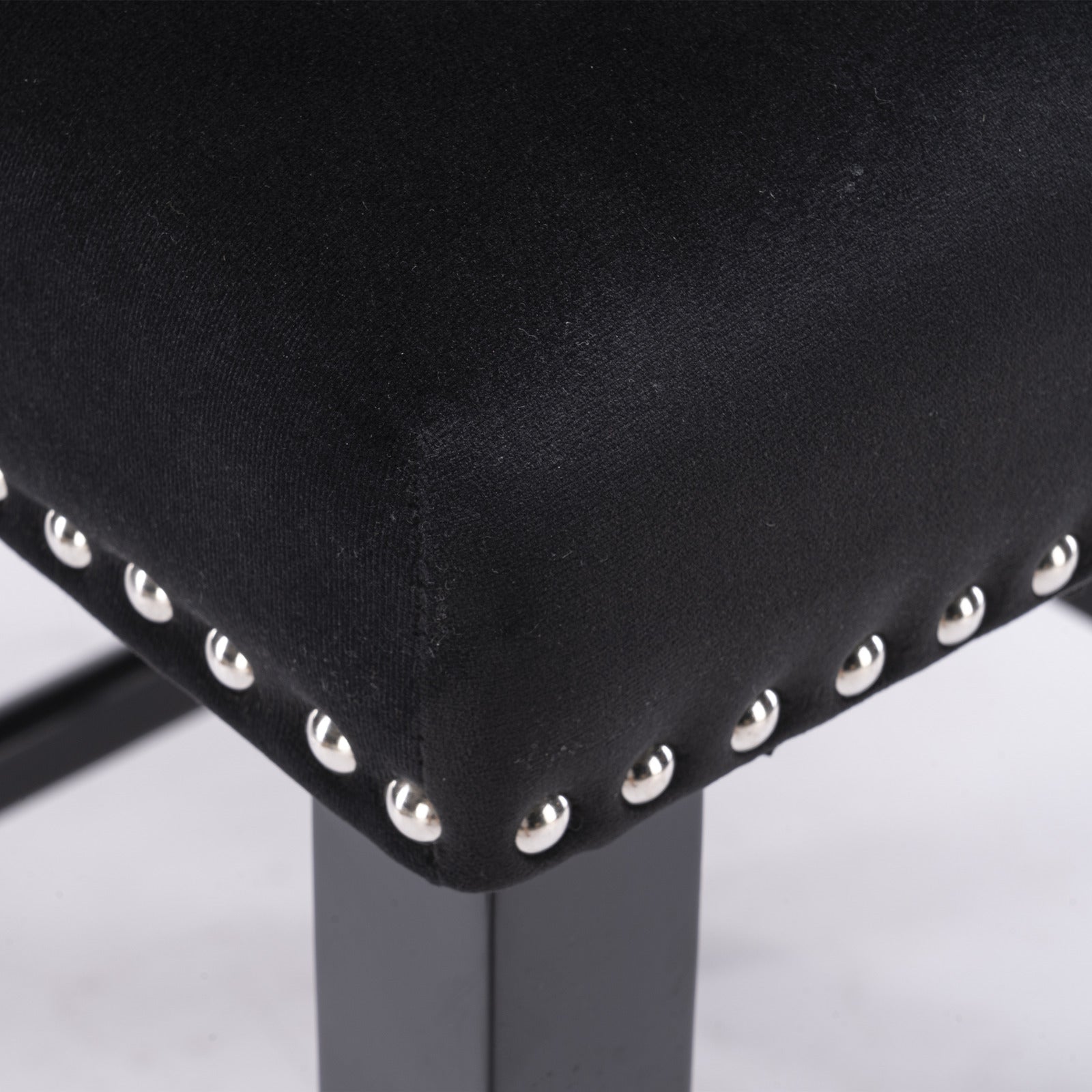 Black upholstered stool seat with silver stud accents and dark metal legs