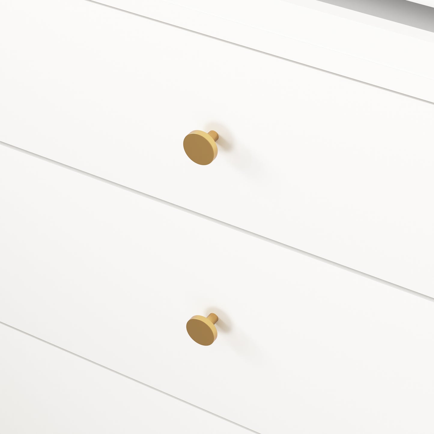 Closeup of two modern brass drawer knobs on a white dresser