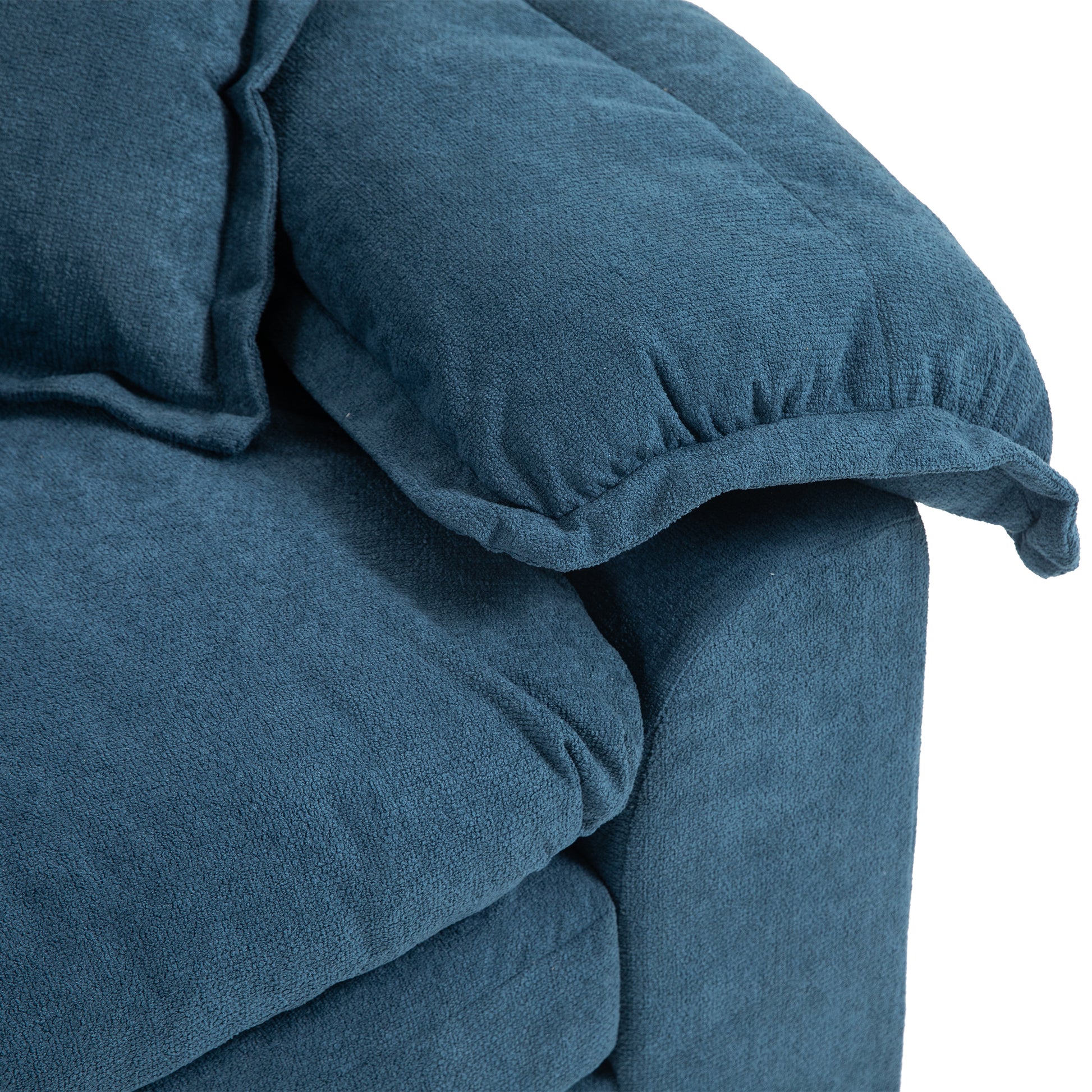 Closeup of a plush navy blue fabric armchair armrest showcasing its textured upholstery and soft cushioning for comfort