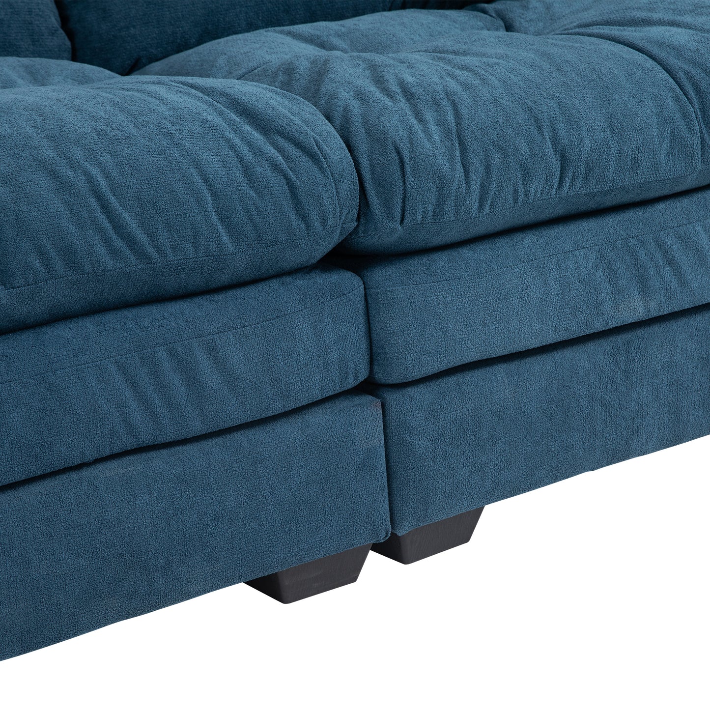 Closeup of plush teal fabric sofa cushions with tufted detailing