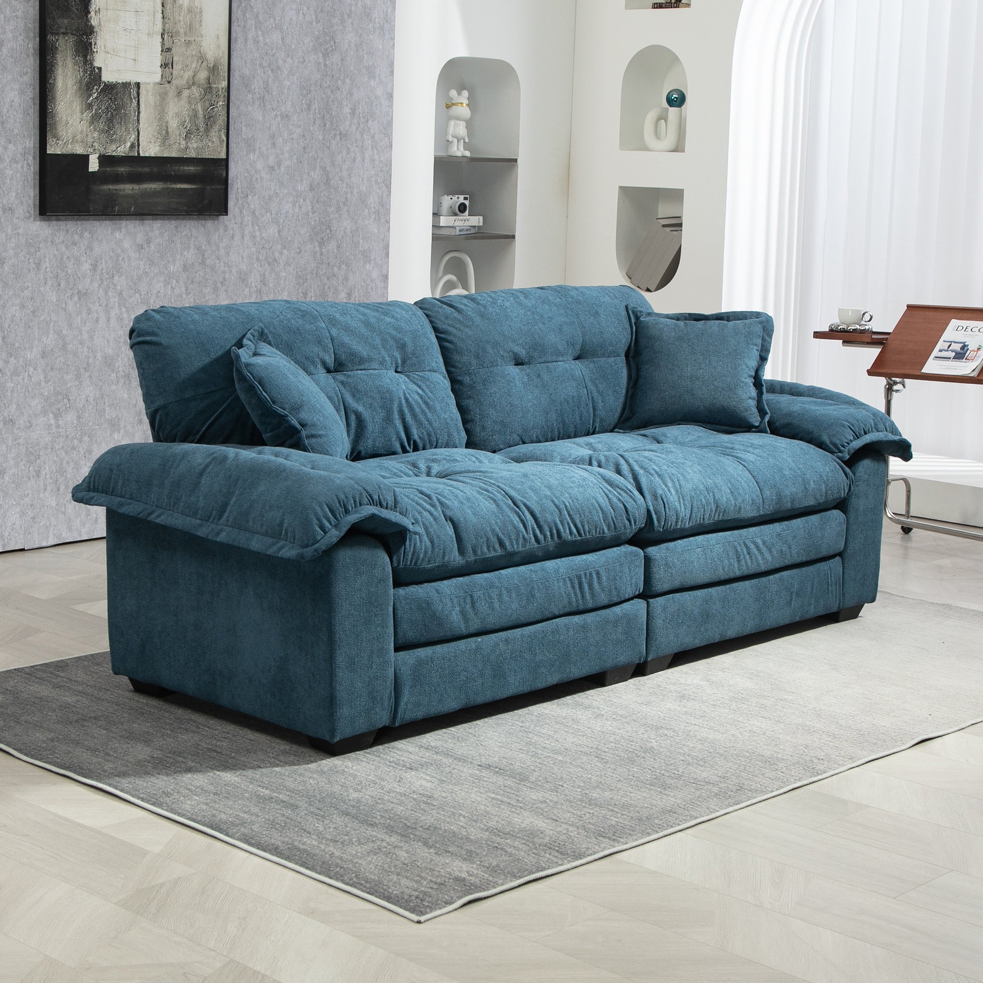 Plush teal velvet sofa with tufted back cushions and loose seat cushions perfect for modern living rooms
