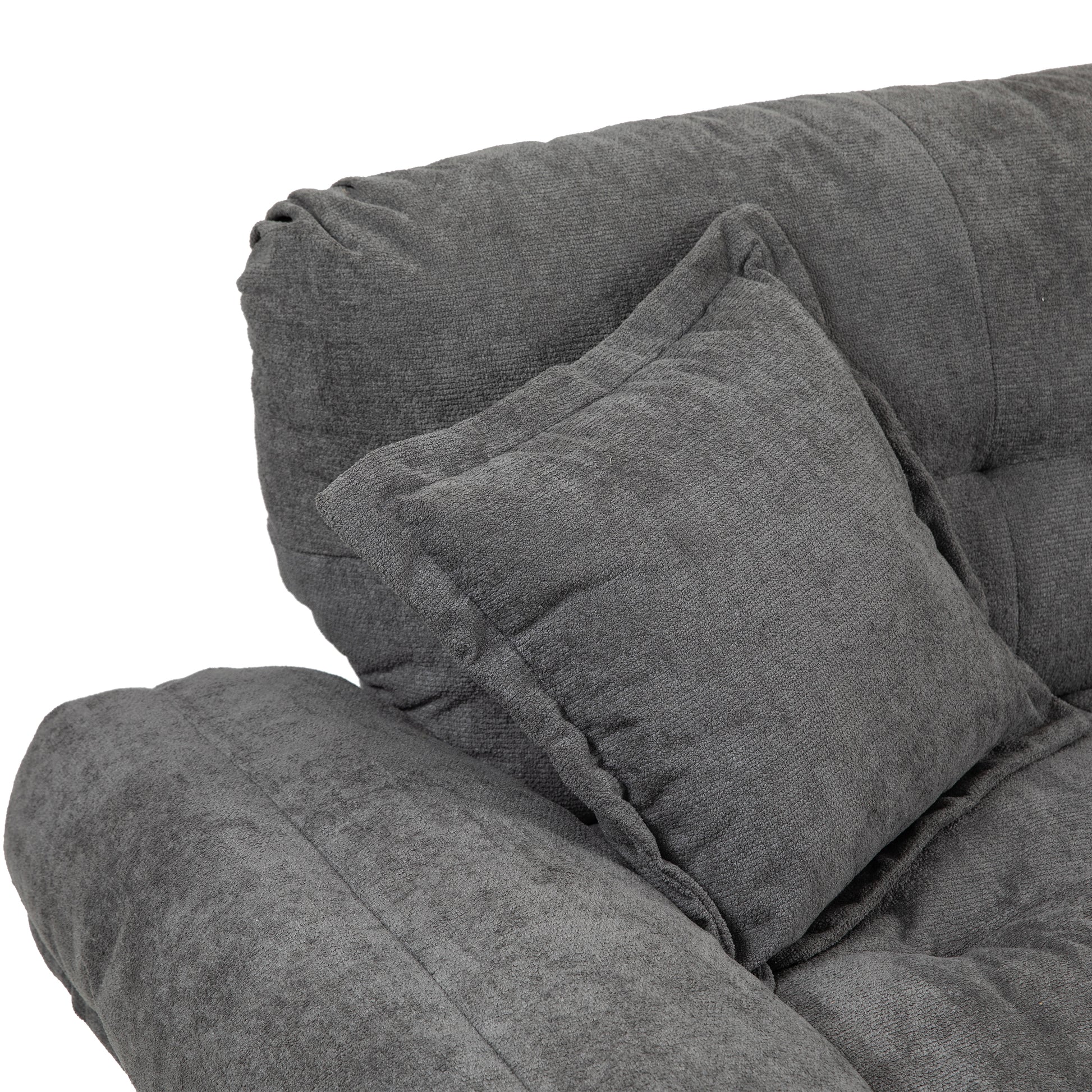 Closeup of a plush grey fabric sofa with a matching throw pillow offering comfort