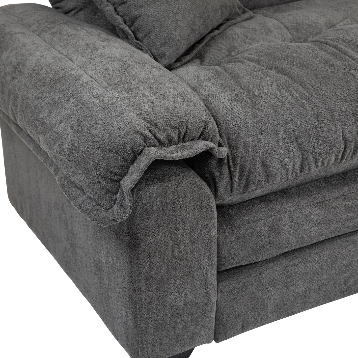 Closeup of a tufted charcoal grey chenille sofa armrest with plush cushions