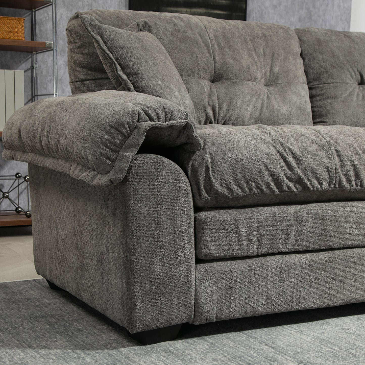 Plush charcoal grey fabric sofa with deep tufted cushions and plush armrests perfect for living rooms