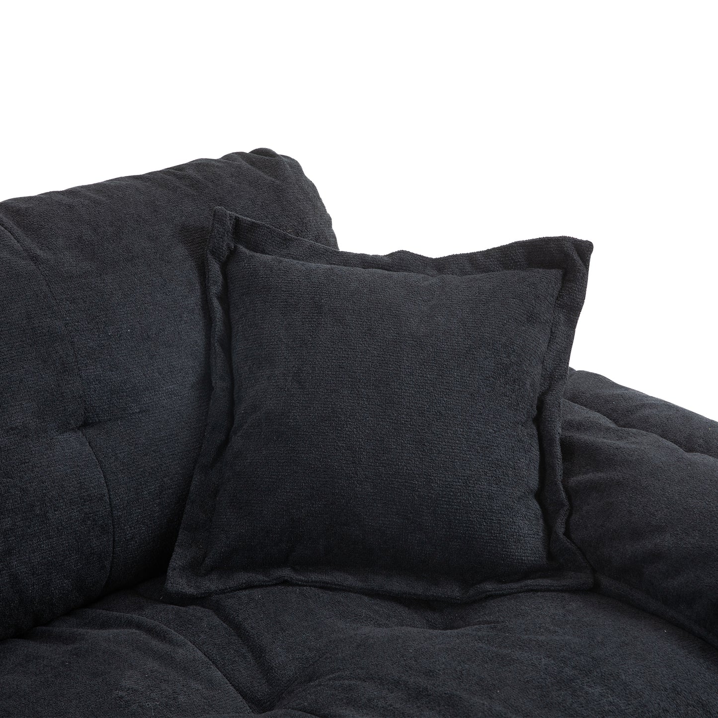 Dark grey textured throw pillow with ruffled edges on a tufted sofa
