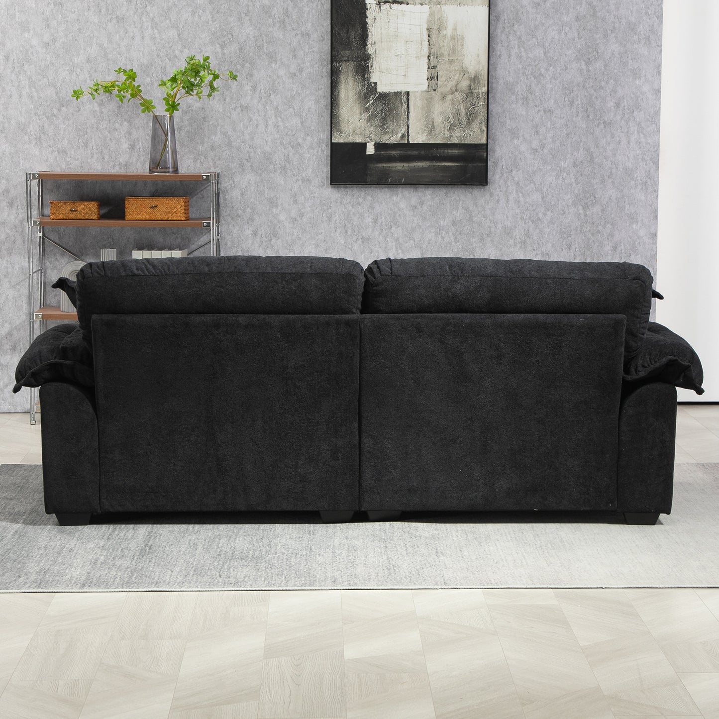 Back view of a plush charcoal gray fabric threeseater sofa with deep seat cushions for comfort