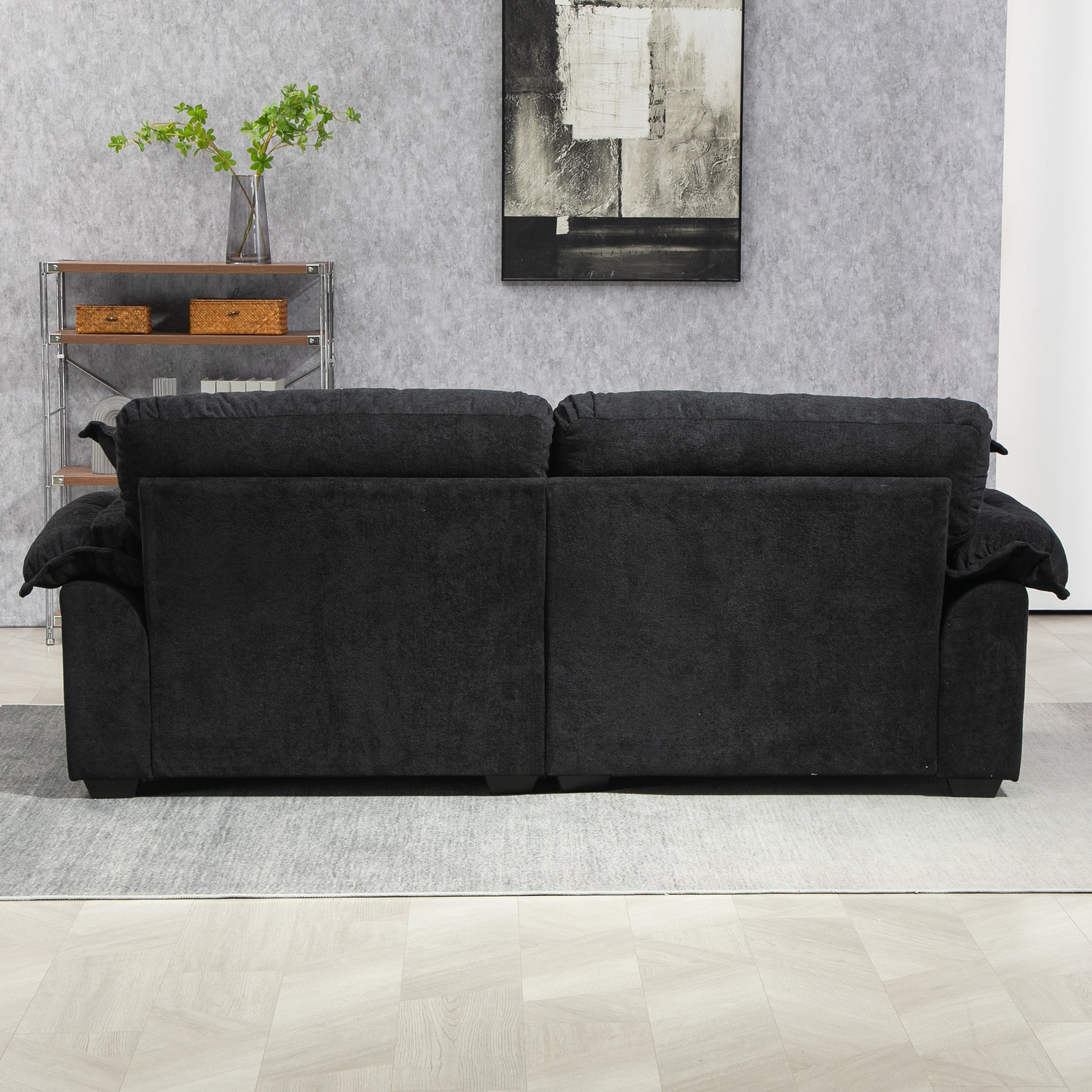 Back view of a plush charcoal gray fabric threeseater sofa with deep seat cushions for comfort