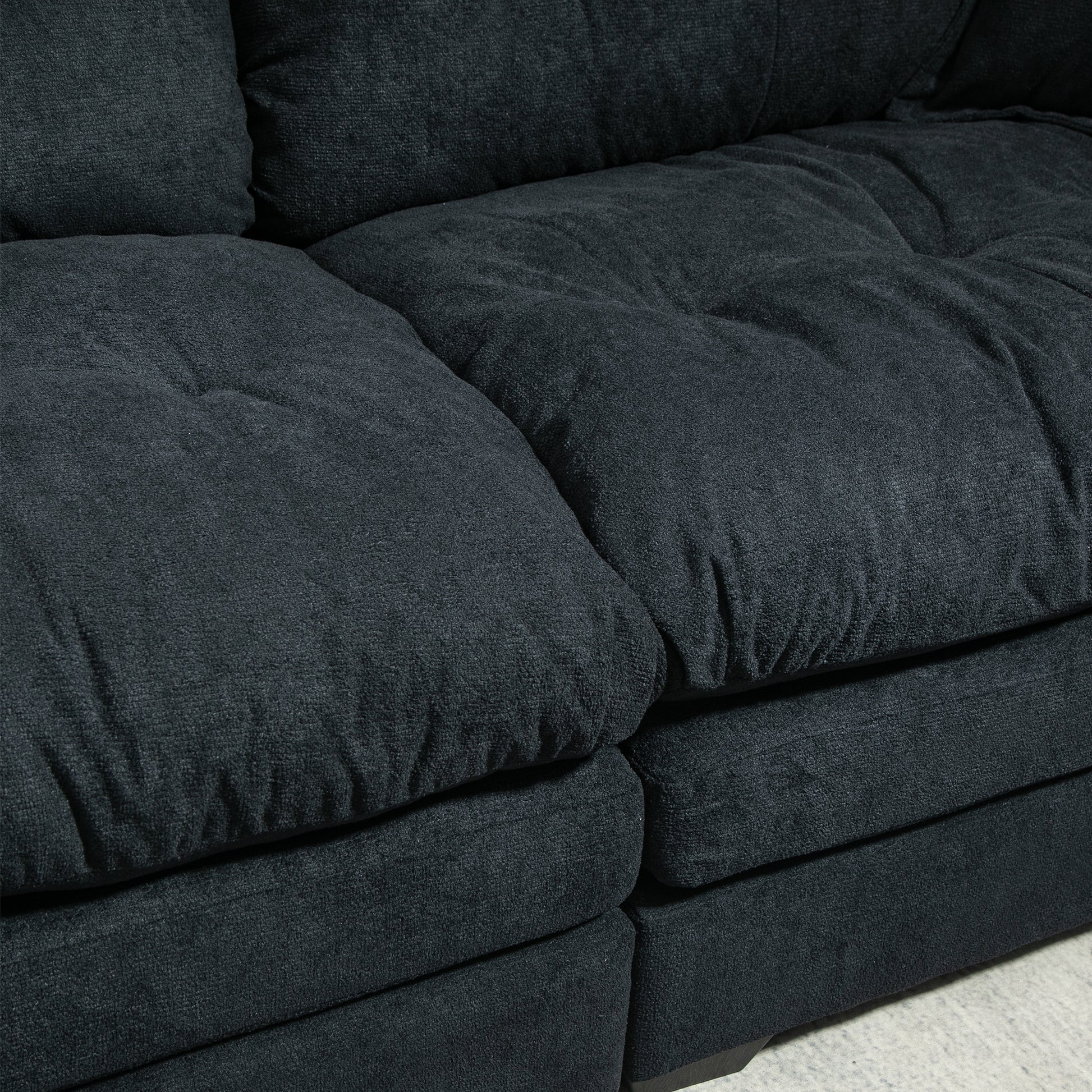 Deep charcoal grey sectional sofa with tufted cushions perfect for modern living rooms