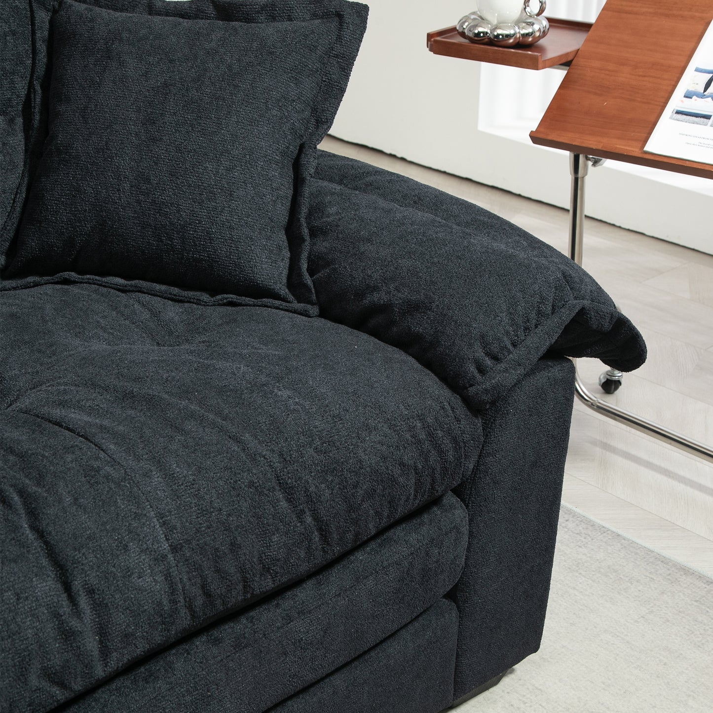 Dark charcoal textured fabric sofa armrest with plush cushioning for comfort