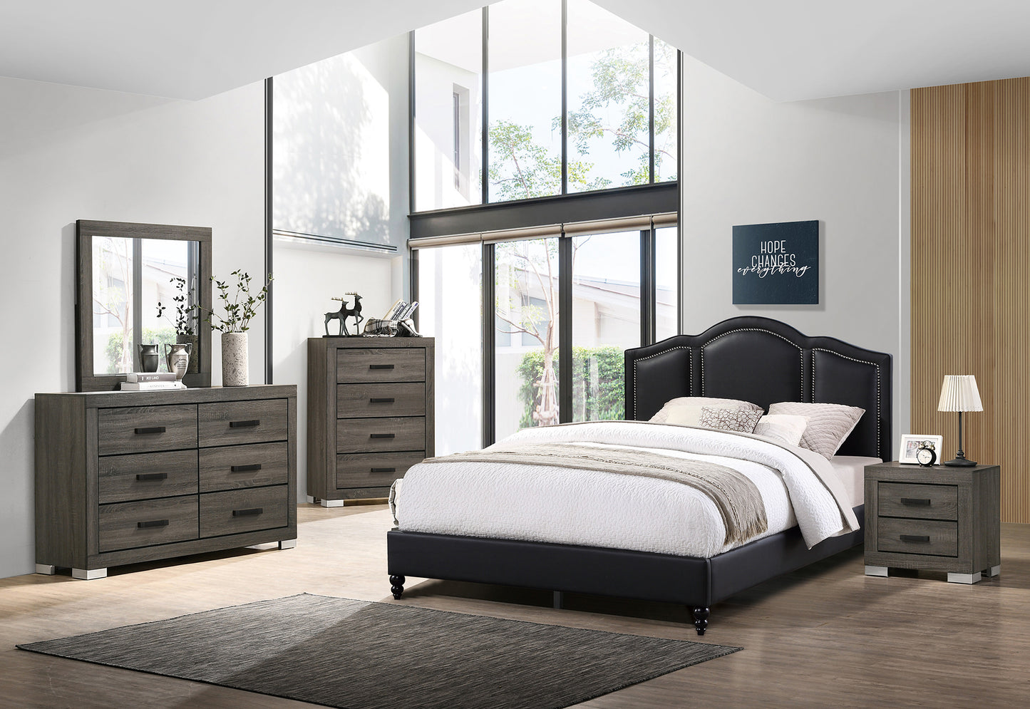 Dark grey upholstered king bed with studded headboard and tufted white bedding