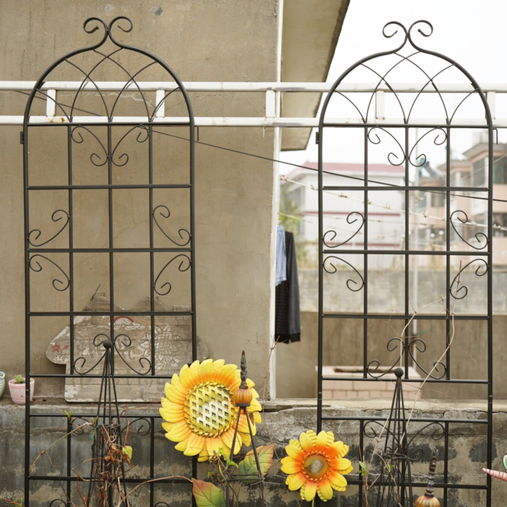 Black wrought iron garden trellis with ornate scrolling for climbing plants and vines