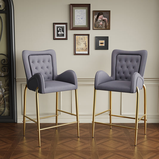 Two grey velvet tufted bar stools with gold legs perfect for a modern kitchen island