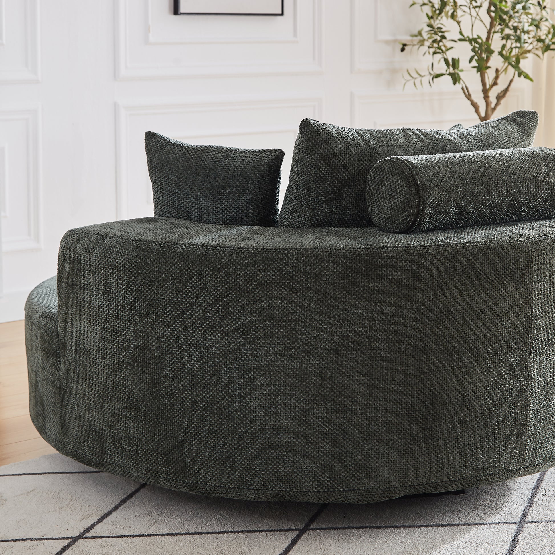 Dark green textured circular sofa with scatter cushions and bolster