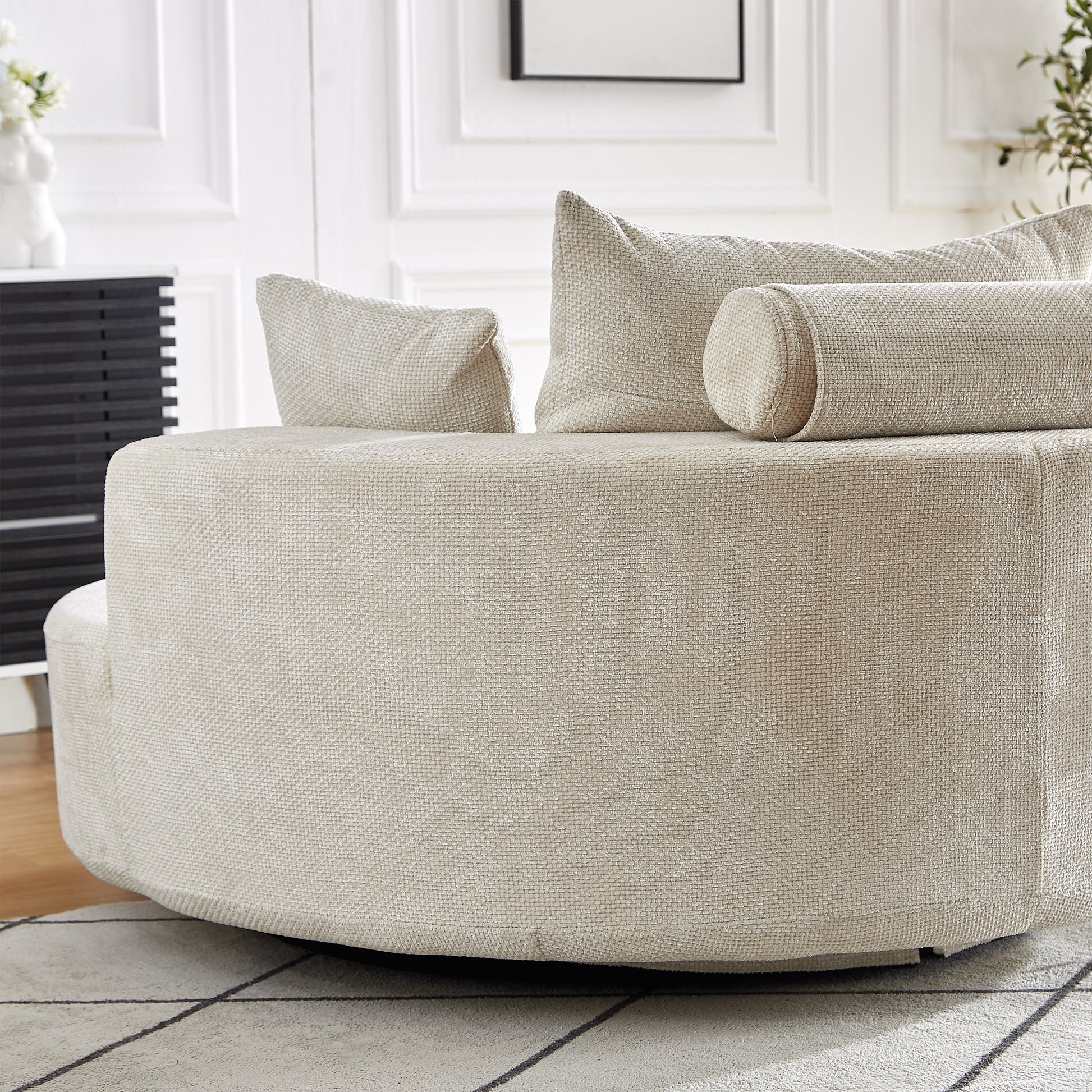 Textured beige fabric swivel armchair with plush back cushions and a bolster pillow
