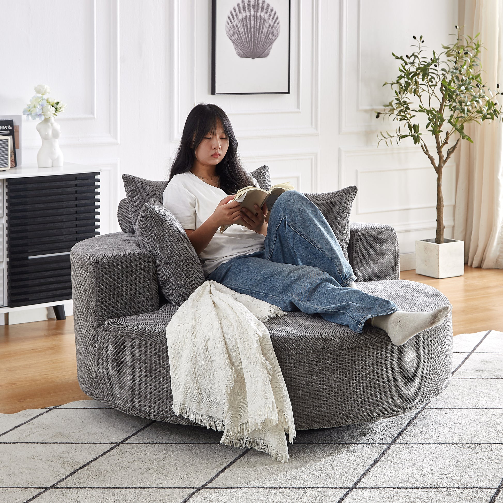 Gray circular chaise lounge with textured fabric and plush cushions perfect for reading