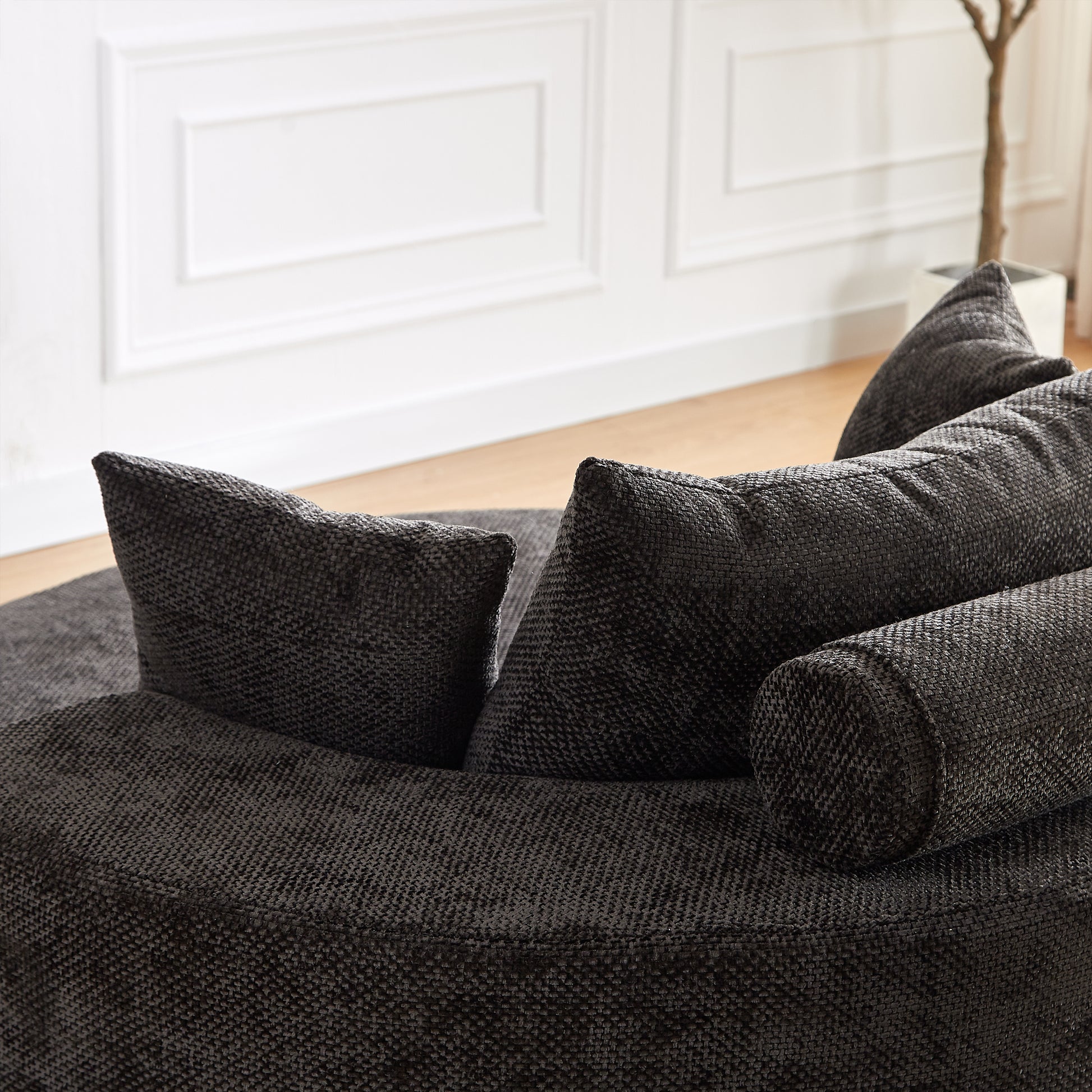 Textured charcoal grey fabric sofa with plush cushions and bolster pillows