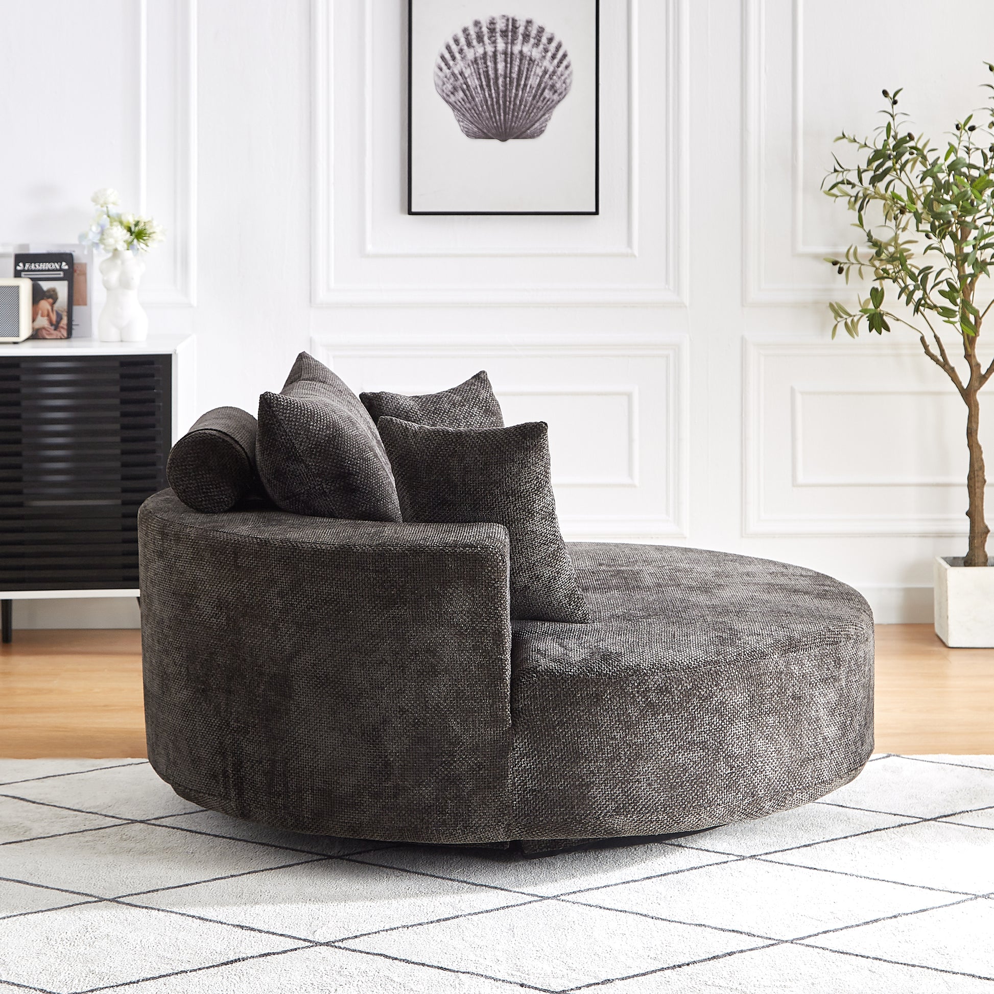 Plush circular swivel armchair in charcoal grey fabric with accent pillows perfect for modern living rooms
