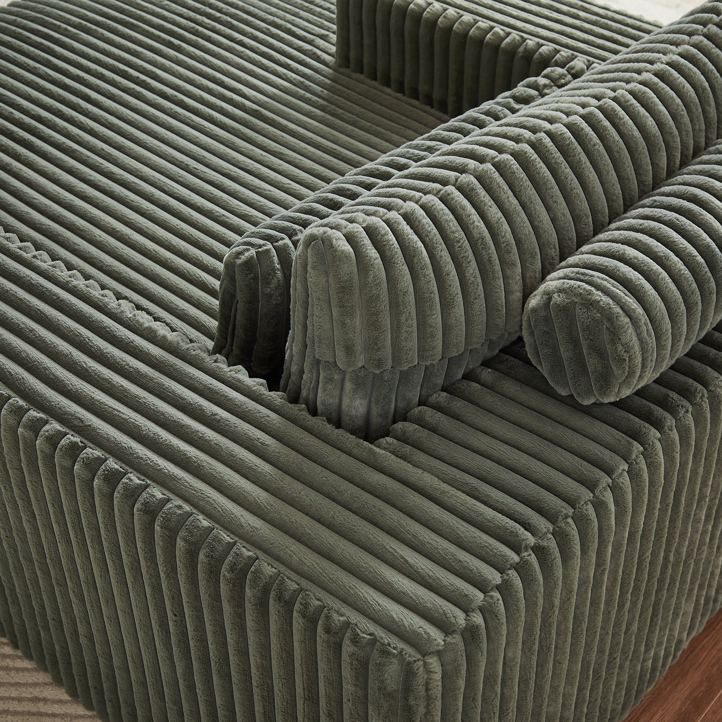 Closeup of a sage green corduroy armchair with plush texture