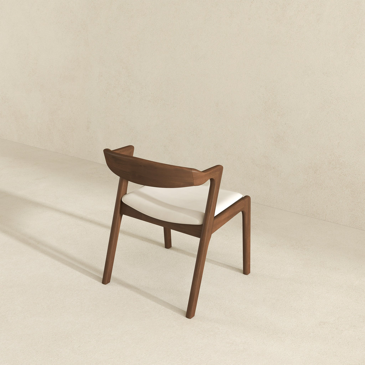 Modern walnut dining chair with a curved wooden backrest and white upholstered seat