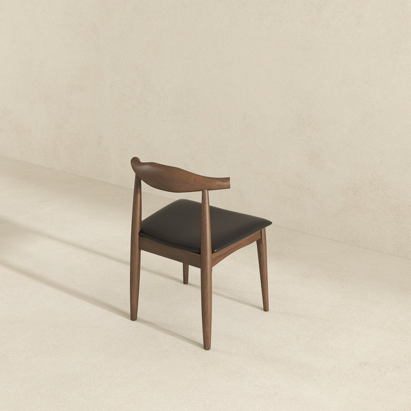 Dark wood dining chair with black leather seat and curved back midcentury modern design
