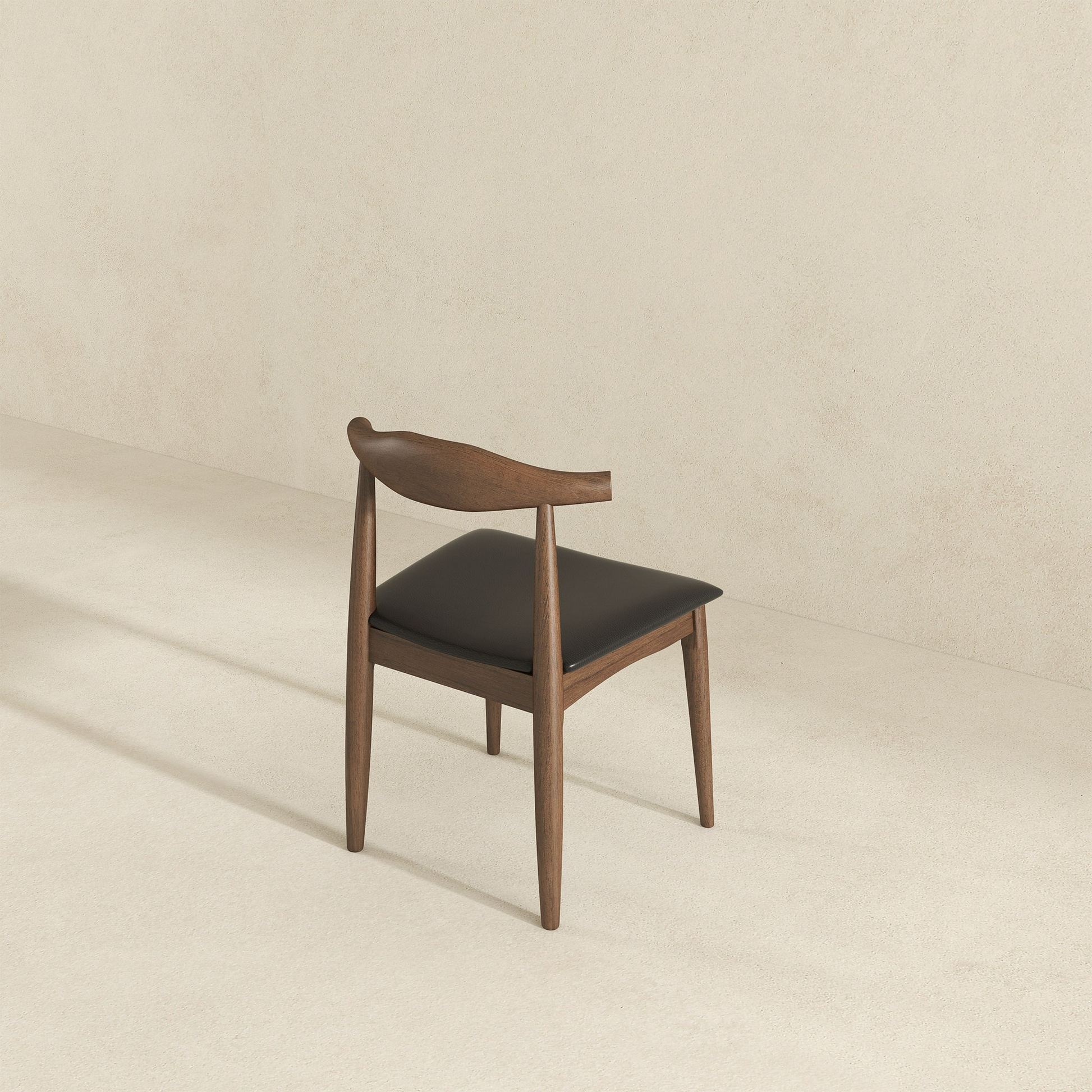 Dark wood dining chair with black leather seat and curved back midcentury modern design