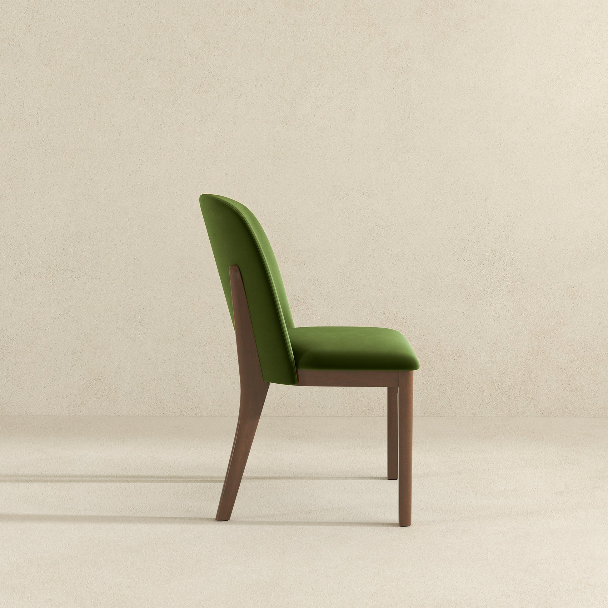 Green velvet dining chair with dark wood legs elegant side profile
