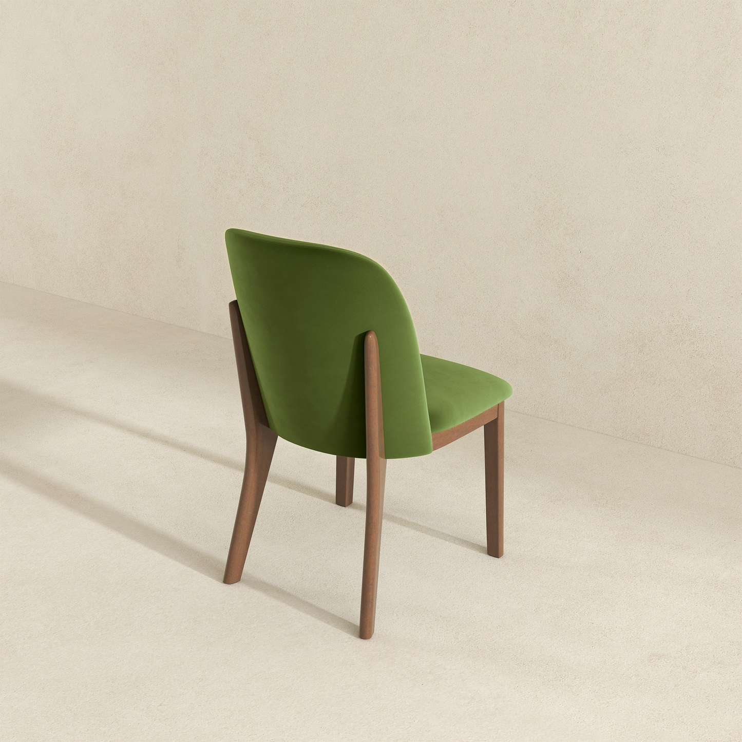 Modern green velvet dining chair with elegant wooden legs and a curved backrest