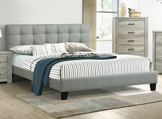 Grey upholstered bed frame with tufted headboard and striped bedding