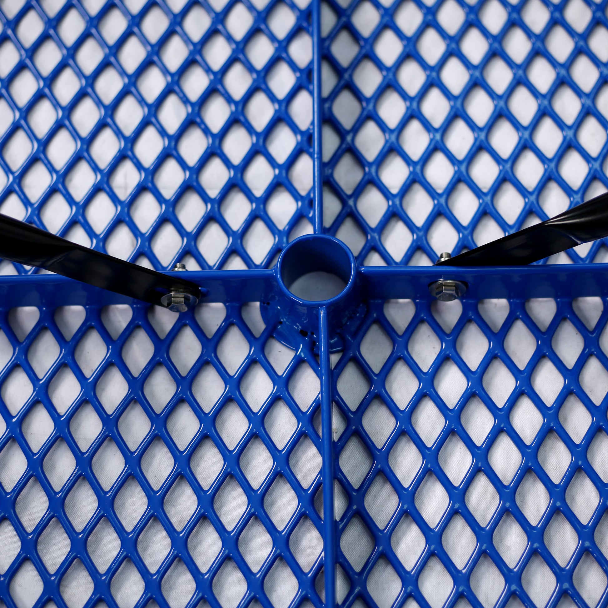 Closeup of a blue expanded metal bench seat with black support arms