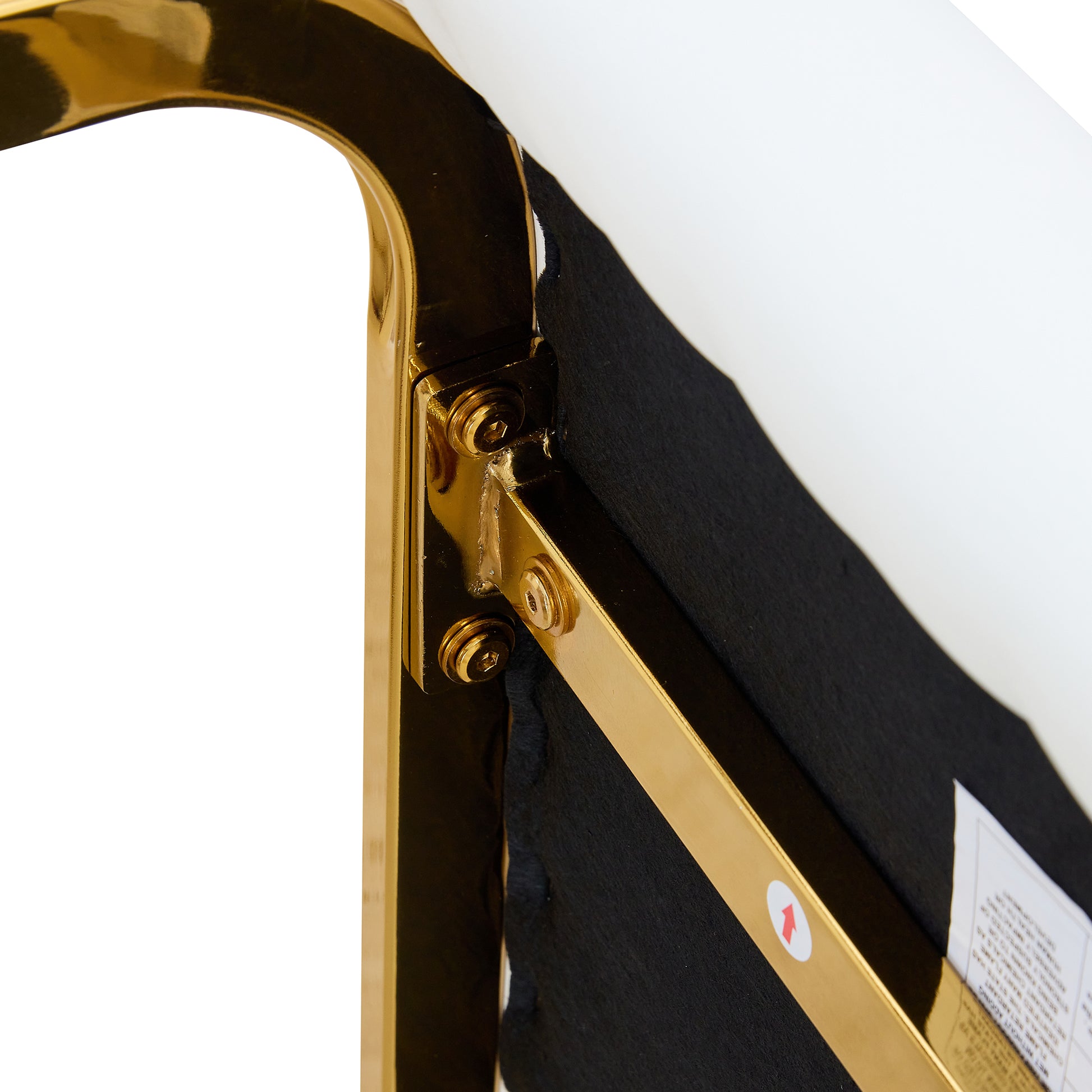 Gold metal frame with visible screws part of a modern chair base