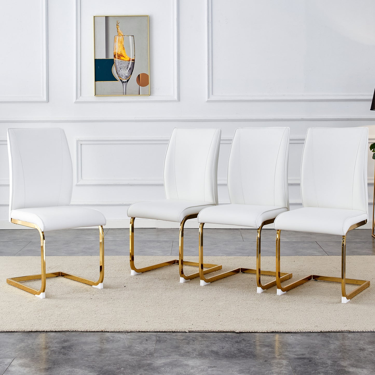 Set of four modern white faux leather dining chairs with sleek gold metal sled legs