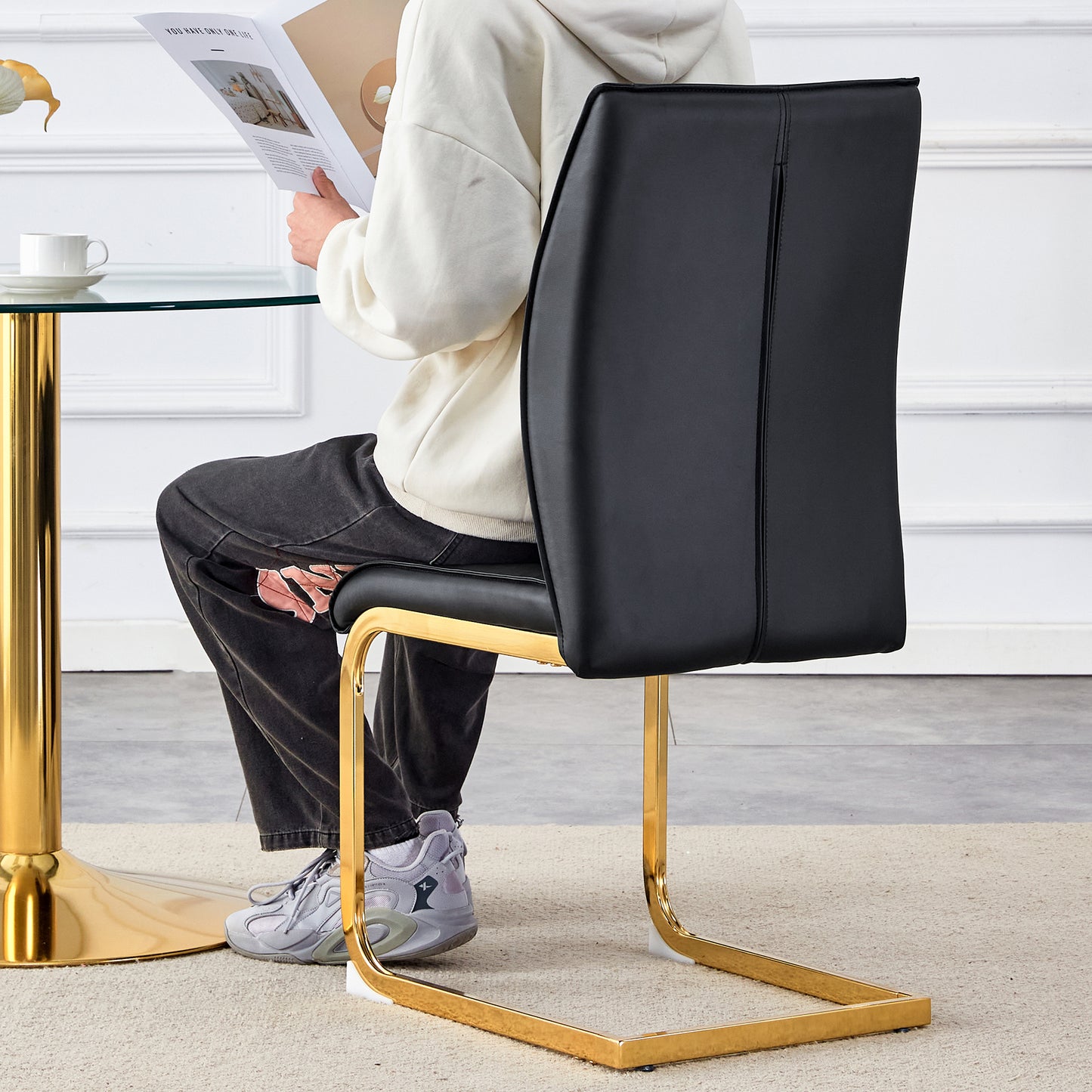 Black faux leather dining chair with sleek gold metal frame