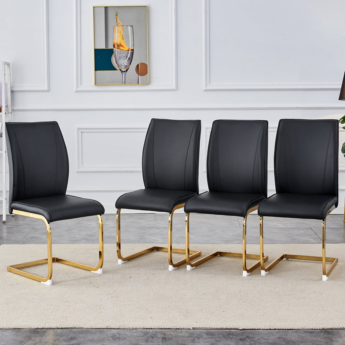 Set of four black faux leather dining chairs with sleek gold metal cantilever bases
