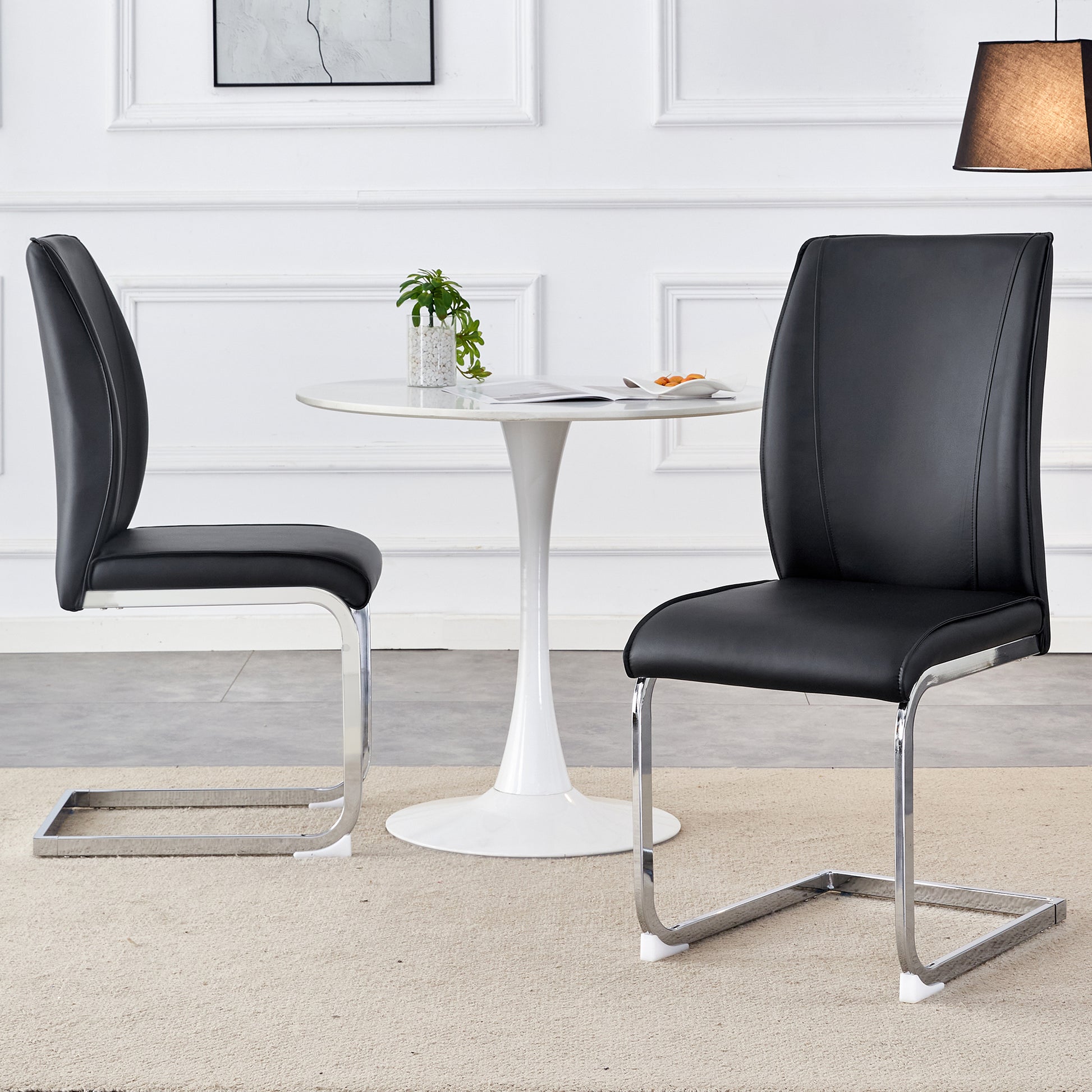 Two black faux leather cantilever dining chairs with chrome legs modern design