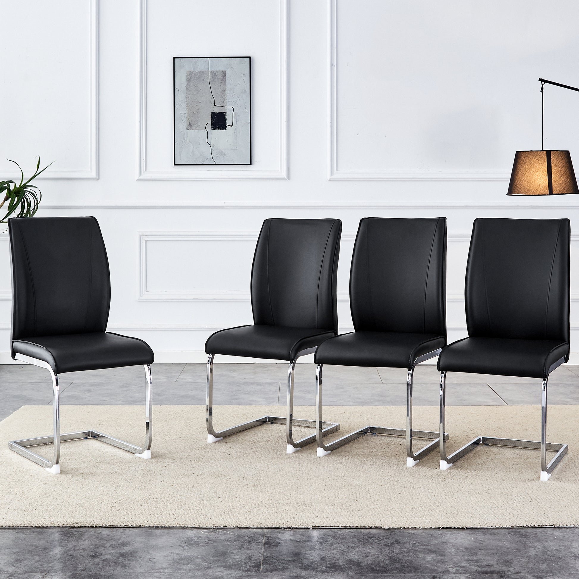 Set of four black faux leather cantilever dining chairs with chrome legs