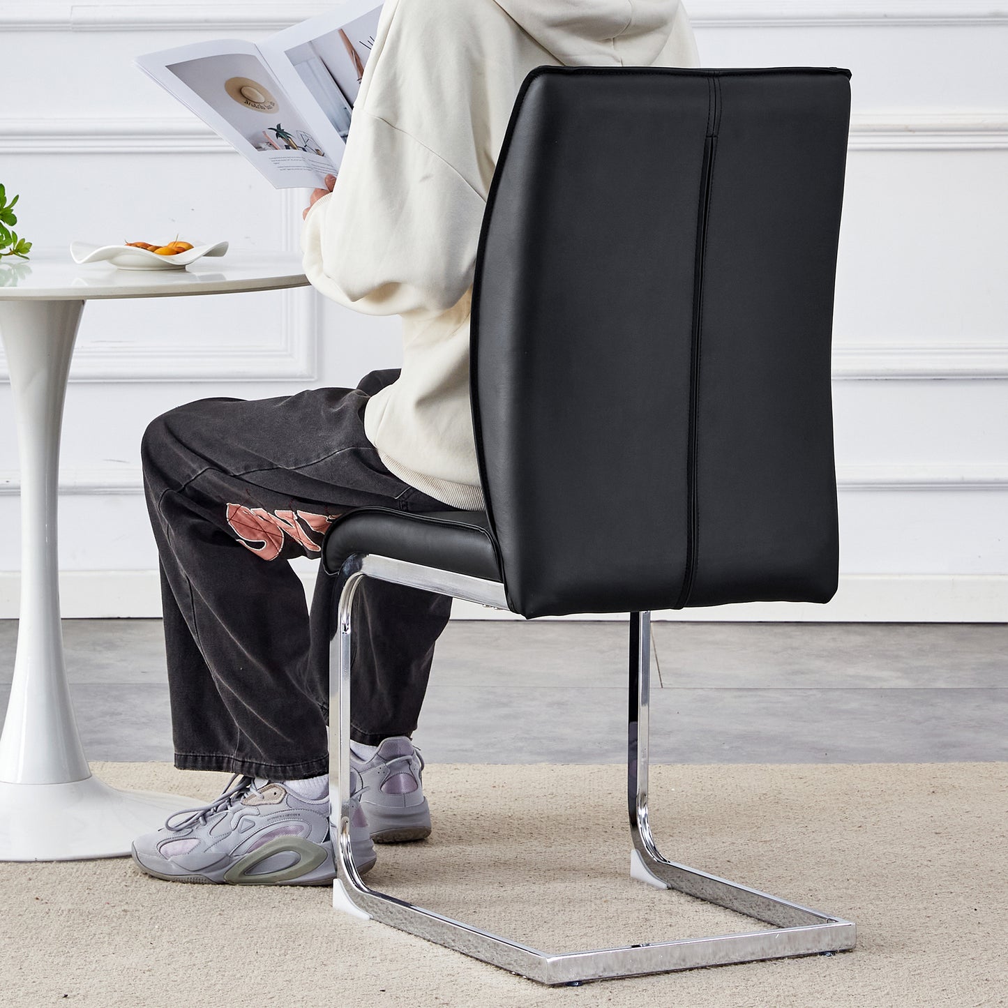 Sleek black faux leather dining chair with chrome cantilever base perfect for modern homes