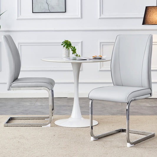 Two grey faux leather dining chairs with chrome sled bases