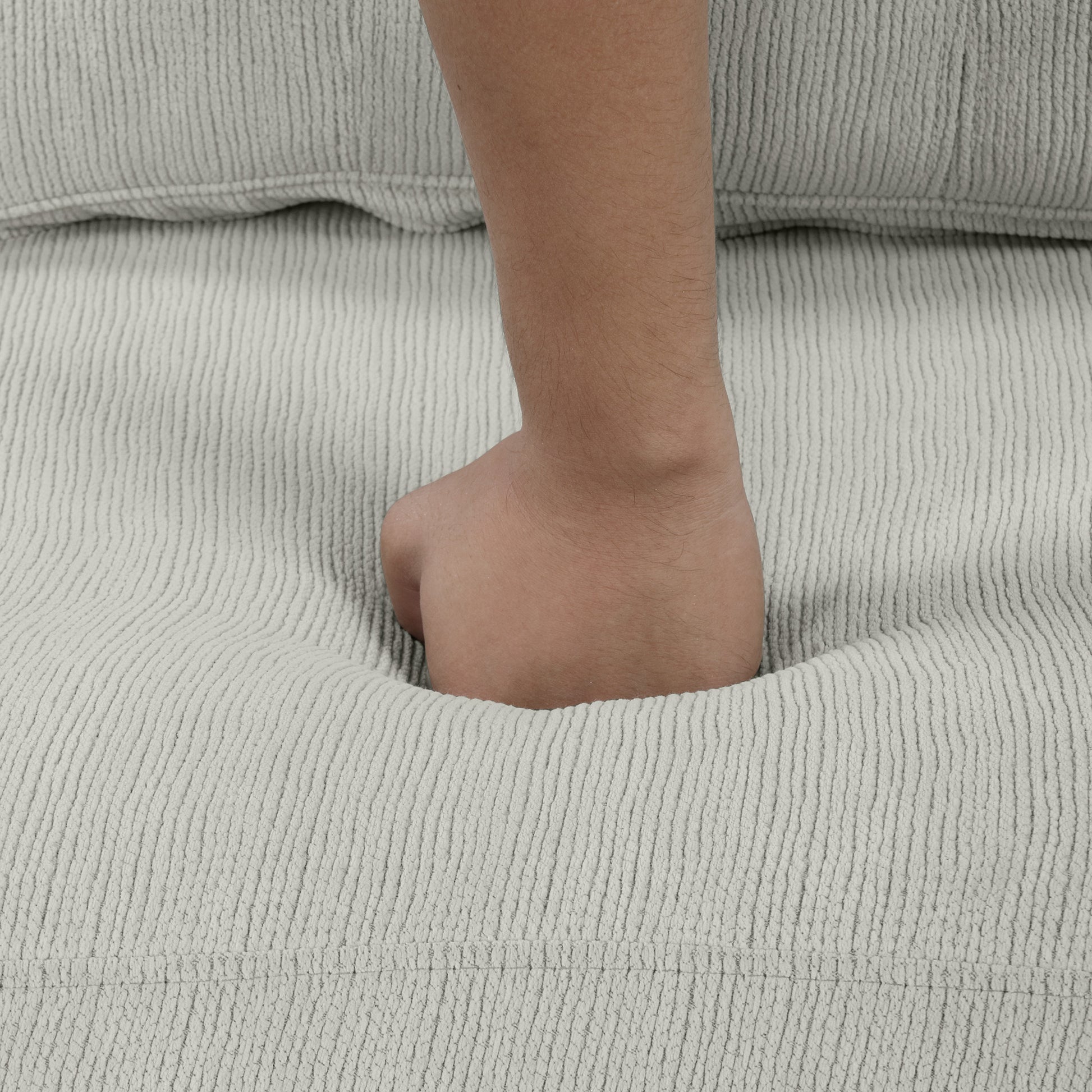 Soft beige corduroy couch cushion indentation showing plush fabric comfort