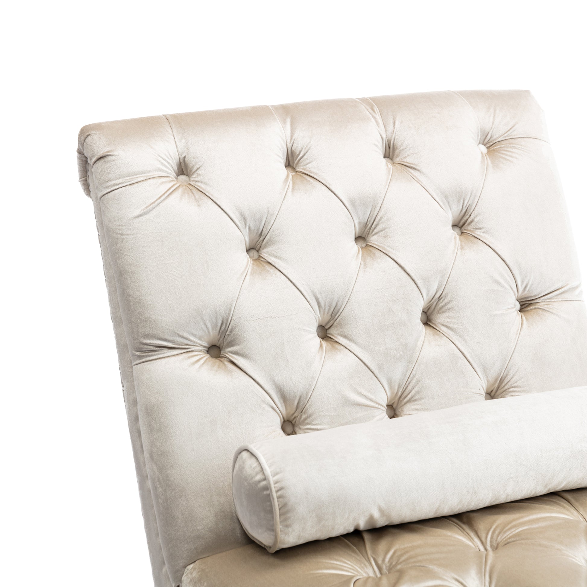 Closeup of a champagne velvet tufted chaise lounge with bolster pillow